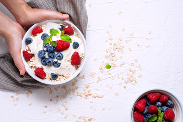 Breakfast, oatmeal with blueberry and raspberry on white bowl in the morning.