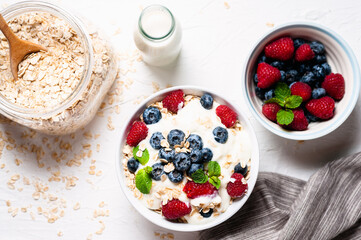 Breakfast, oatmeal with blueberry and raspberry on white bowl in the morning.