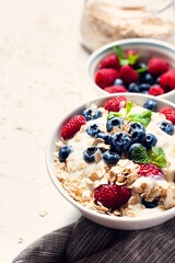 Breakfast, oatmeal with blueberry and raspberry on white bowl in the morning.
