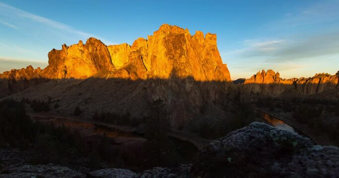 Panning time lapse shot of sunrise over river amidst rock formations at Smith Rock State Park - Terrebonne, Oregon