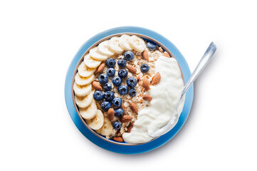 Breakfast, oatmeal with blueberry, banana almond and yogurt on a bowl in the morning.