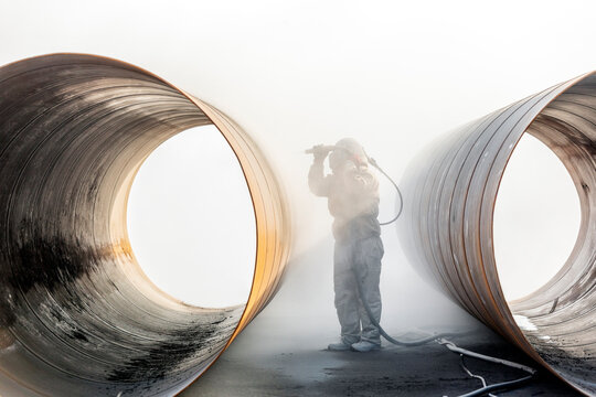 View of sandblasting before coating. Abrasive blasting, more commonly known as sandblasting, is the operation of forcibly propelling a stream of abrasive material against a surface.