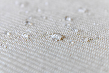 Light fabric texture with water drops. Abstract background. Selective focus.