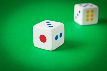 Dice on a green playing table. Close up. The concept of luck in gambling.