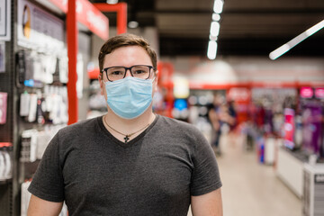 Fototapeta na wymiar Caucasian man shopping for clothes with medical mask. New normal concept. 