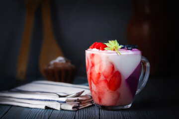 Panna-cotta, dessert. Jelly, whipped cream pudding of berries and gelatin. A cupcake, a rough cloth napkin and a dessert spoon. Picture, picture.
