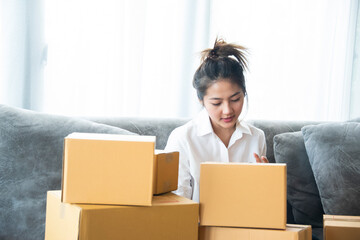 Woman packing and check address customers who order shopping online,work from home and delivery concept for COVID-19 prevention
