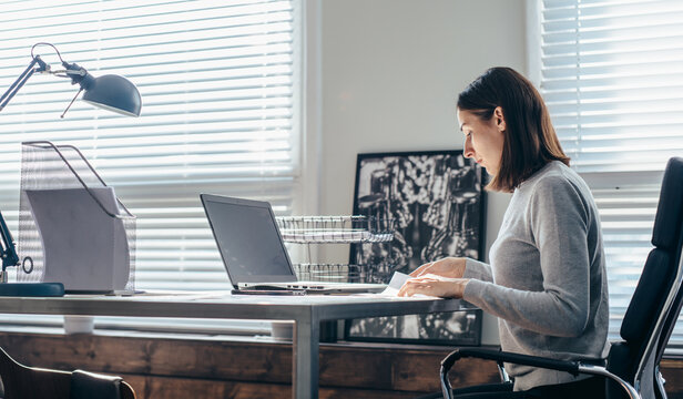 Woman works at desk with laptop in office