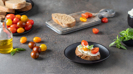 Making Appetizer bruschetta with bread, cream cheese and d tomato cherry. Lifestyle cooking image
