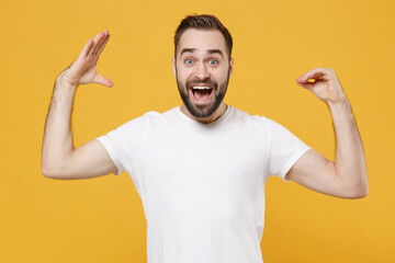 Excited young bearded man guy 20s in white casual t-shirt posing isolated on yellow background studio portrait. People lifestyle concept. Mock up copy space. Showing blah blah gesture ja jaja hands. © ViDi Studio