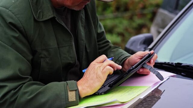 Forester Writing Sheet of Paper From Side Close Up Detail