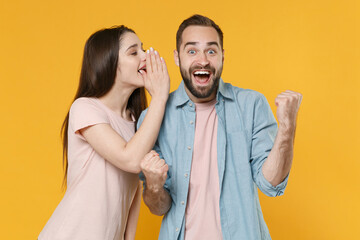 Excited young couple friends guy girl in casual clothes isolated on yellow background. People...