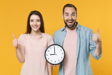 Excited young couple two friends guy girl in pastel blue casual clothes posing isolated on yellow...