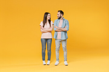 Smiling young couple two friends guy girl in pastel blue casual clothes posing isolated on yellow...