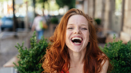 Young woman laughing at the camera - obrazy, fototapety, plakaty