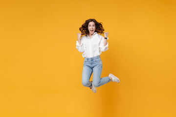 Fototapeta na wymiar Happy young brunette business woman in white shirt posing isolated on yellow background studio portrait. Achievement career wealth business concept. Mock up copy space. Jumping, doing winner gesture.