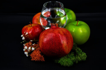 art photo glass of water red and green apples moss of different colors on a black background 2