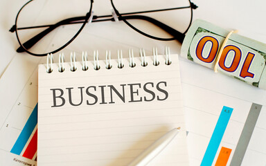 Business reports, blank paper sheet, glasses and charts - directly above view of office table...