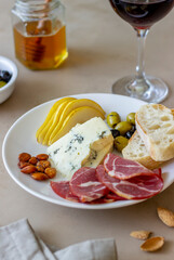 Wine snack. Prosciutto, Parma ham, almonds, olives, baguette, blue cheese. Antipasti.