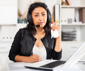 Disappointed female customer support phone operator during work