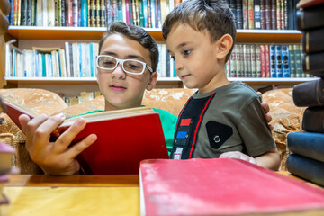 Muslim arabic boy reading book in library