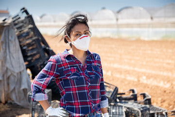 Hispanic female farmer in medical face mask