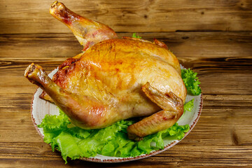 Baked whole chicken on a wooden table