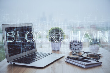 Multi exposure of blockchain and crypto economy theme hologram and table with computer background. Concept of bitcoin cryptocurrency.