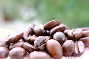 Fototapeta premium close up coffee beans on wood table and macro coffee beans background