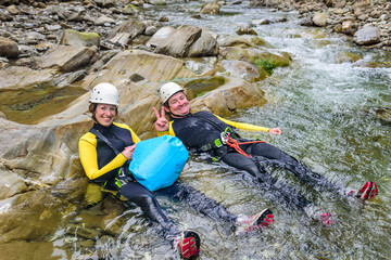Paar genießt das kühle Nass eines Wildbachs beim Canyoning

