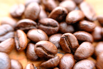 Naklejka premium close up coffee beans on wood table and macro coffee beans background