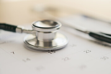 Stethoscope with calendar page date on wood table background doctor appointment medical concept