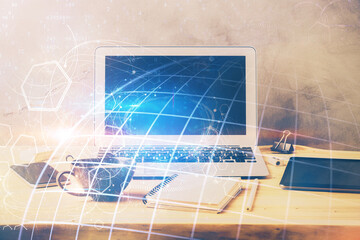 Multi exposure of table with computer and world map hologram. International data network concept.