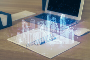 Desktop computer background in office and big town buildings hologram drawing. Double exposure. Smart city concept.