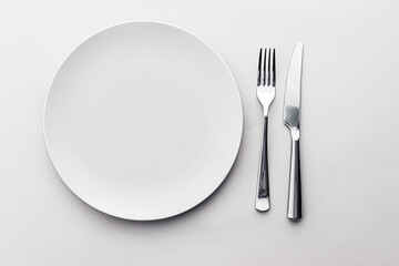 Empty plate and cutlery as mockup set on white background, top tableware for chef table decor and...