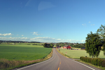 Fototapeta na wymiar A typical Norwegian road in the countryside. Ostfold Region, Norway