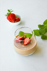 Chocolate dessert decorated with strawberries and Melissa leaves