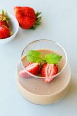 Chocolate dessert decorated with strawberries and Melissa leaves