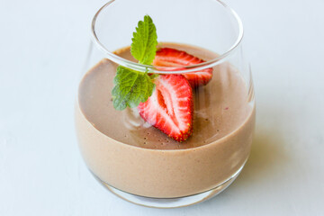 Chocolate dessert decorated with strawberries and Melissa leaves