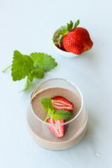 Chocolate dessert decorated with strawberries and Melissa leaves