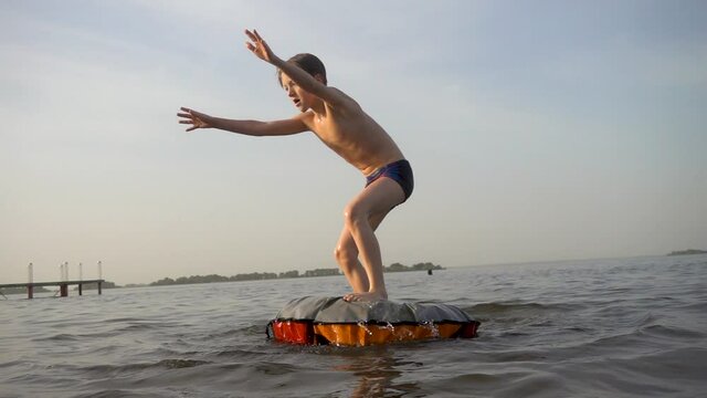 The boy does a somersault on the water. Slow-motion