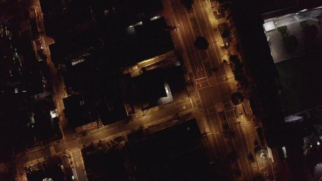 Drone shot in the night of the city of Quito, Ecuador. Overlooking empty streets with lights during quarantine. Buildings, houses and no cars passing by.