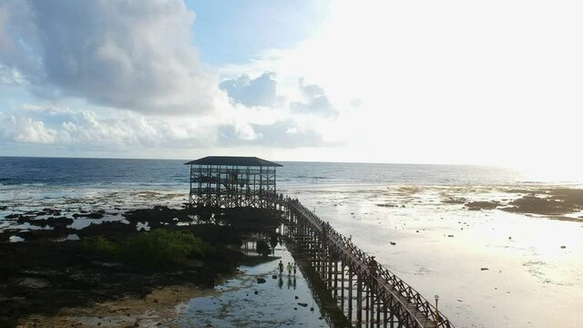 Beautiful drone shot of surfing tower in Siargao with people walking on the plankway