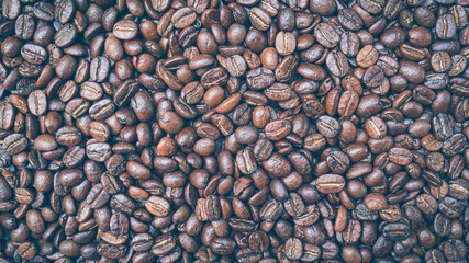 Brown roasted whole coffee beans background. Dark roast for your brewing method. Seed nature from above view. Group agriculture grain arabica. Photos from the top view.