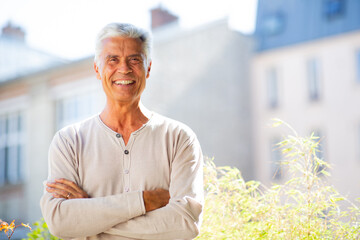handsome old man smiling with arms crossed
