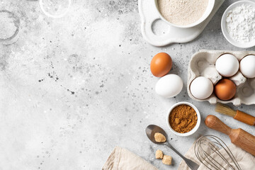 Obraz na płótnie Canvas Ingredients for baking on a culinary background. Eggs, flour, cinnamon, sugar, soda on the kitchen table. Concept of preparation for baking. Top view with space for text