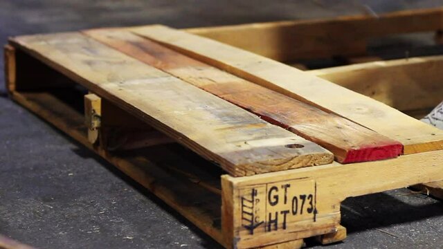 A wooden pallet being deconstructed for its pieces.