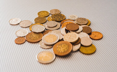 Many different coins from different countries from the black wallet are scattered around the table: dollars, pounds, rubles, pennies, cents, yuan. Saving money, losing finance, earning.