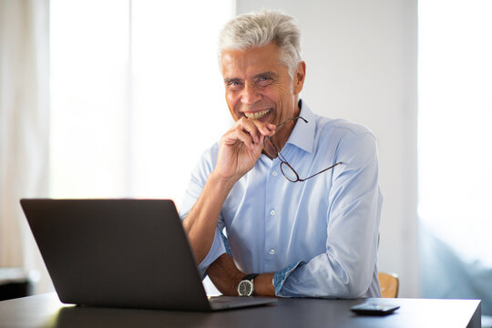 Close Up Older Businessman Sitting At Office Desk With Laptop Computer