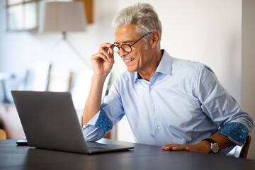 Close up businessman with glasses looking at laptop computer